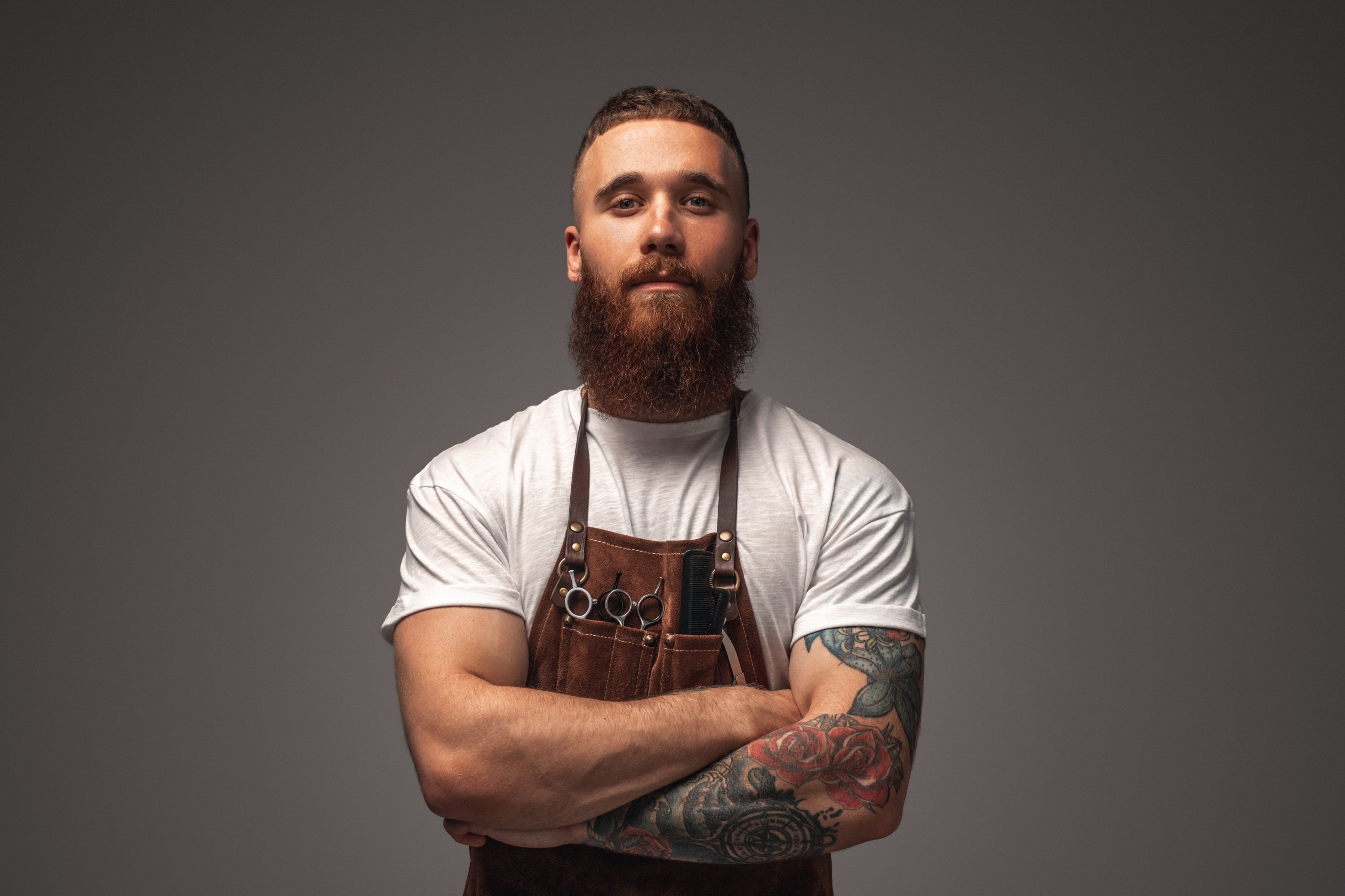 man with full beard standing with arms crossed